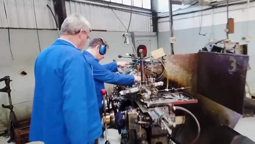 Two artisans working together at the lathe